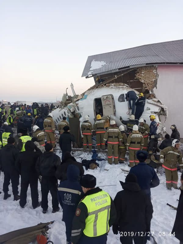 Emergency and security personnel are seen at the site of the plane crash near Almaty