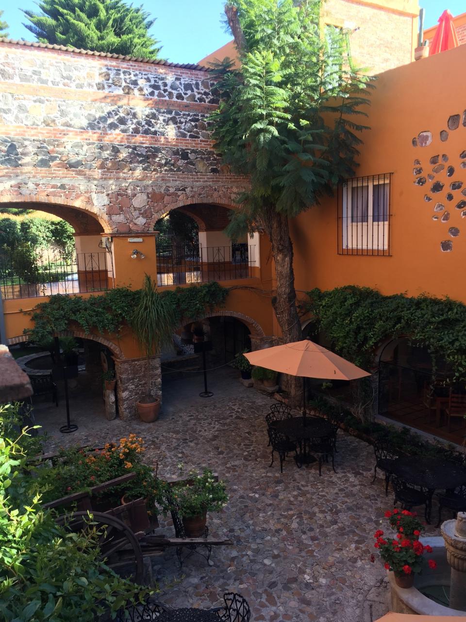 This Nov. 23, 2018 photo provided by Kim Curtis shows a courtyard garden in San Miguel de Allende, Guanajuato, Mexico. Step off the dusty cobblestone streets and peek behind nondescript, weather-worn brick facades and encounter the startlingly beautiful courtyard gardens of the central Mexican town of San Miguel de Allende. These oases of beauty and calm claim their roots in the traditional Moorish gardens of ancient Spain. (Kim Curtis via AP)