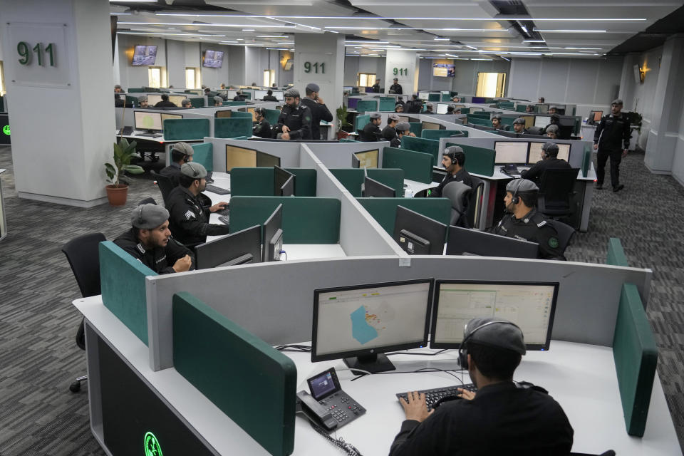 Saudi police officers monitor screens displaying the Grand Mosque, at the 911 monitoring center, ahead of the Hajj pilgrimage in the Muslim holy city of Mecca, Saudi Arabia, Friday, June 23, 2023. Muslim pilgrims are converging on Saudi Arabia's holy city of Mecca for the largest hajj since the coronavirus pandemic severely curtailed access to one of Islam's five pillars. (AP Photo/Amr Nabil)