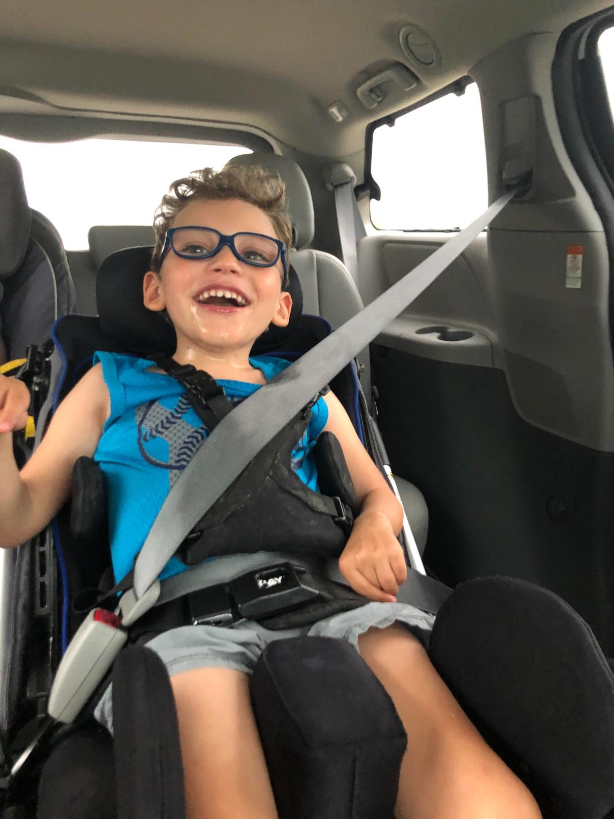 Nine-year-old Gage Wingo smiles in the back of his family's car. When a family member helped the Wingo family purchase a van that would accommodate Gage's wheelchair, it inspired his mom Hannah Wingo to help others in similar situations.