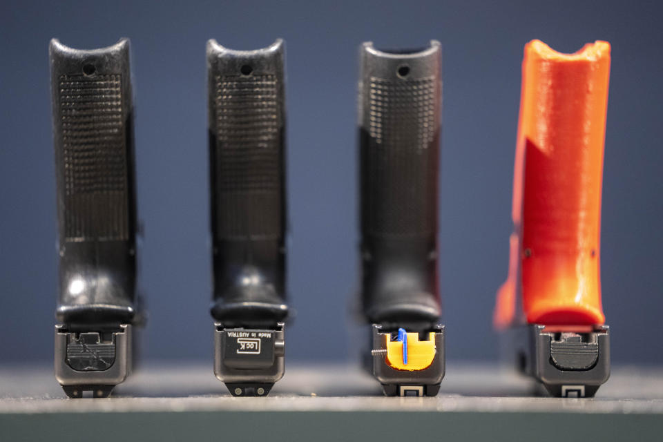 A row of semi-automatic pistols is displayed for a photograph, some with conversion devices installed making them fully automatic, at the Bureau of Alcohol, Tobacco, Firearms, and Explosives (ATF), National Services Center, Thursday, March 2, 2023, in Martinsburg, W.Va. Machine guns have been illegal in the U.S. for decades, but in recent years the country has seen a new surge of weapons capable of automatic fire. The small pieces of plastic or metal used to convert legal guns into homemade machine guns are helping to fuel gun violence. (AP Photo/Alex Brandon)