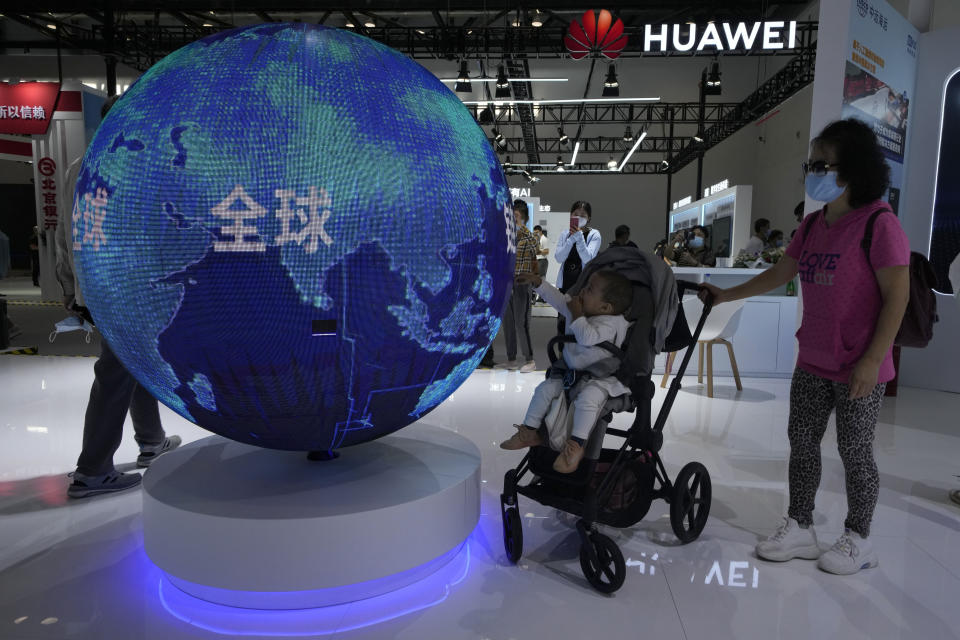 A child reaches out to a depicting of a globe and the word "Global" during the China International Fair for Trade in Services (CIFTIS) in Beijing, China, Monday, Sept. 6, 2021. The ruling Communist Party's campaign to tighten control over China's industries and reduce use of foreign technology is slashing economic growth, a foreign business group warned Thursday, Sept. 22 and it appealed to Beijing to reverse course and open state-dominated markets wider. (AP Photo/Ng Han Guan)