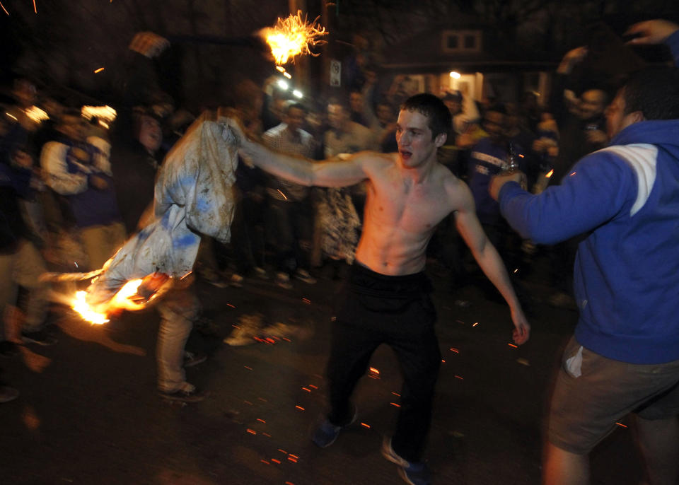 A University of Kentucky student holds a burning cloth as students and fans of the university take to the streets after the University of Connecticut defeated Kentucky in the NCAA men's National Basketball Championship near the university campus in Lexington, Kentucky, April 7 2014. REUTERS/ John Sommers II (UNITED STATES - Tags: SPORT BASKETBALL)