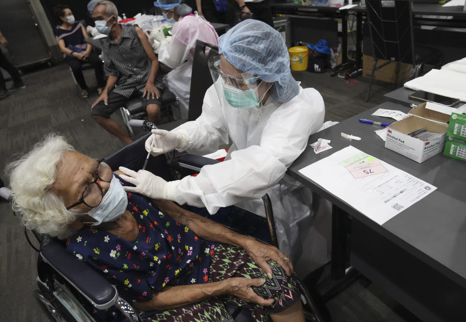 A health worker administers a dose of the AstraZeneca COVID-19 vaccine to a woman at Paragon shopping mall in Bangkok, Thailand, Monday, June 7, 2021. Health authorities in Thailand on Monday began their much-anticipated mass rollout of locally produced AstraZeneca vaccine, but it appeared that supplies were falling short of demand from patients who had scheduled vaccinations for this week. (AP Photo/Sakchai Lalit)