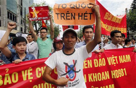 A protester holds a placard which reads, "nation first" while marching during an anti-China protest on a street in Hanoi May 11, 2014. REUTERS/Kham