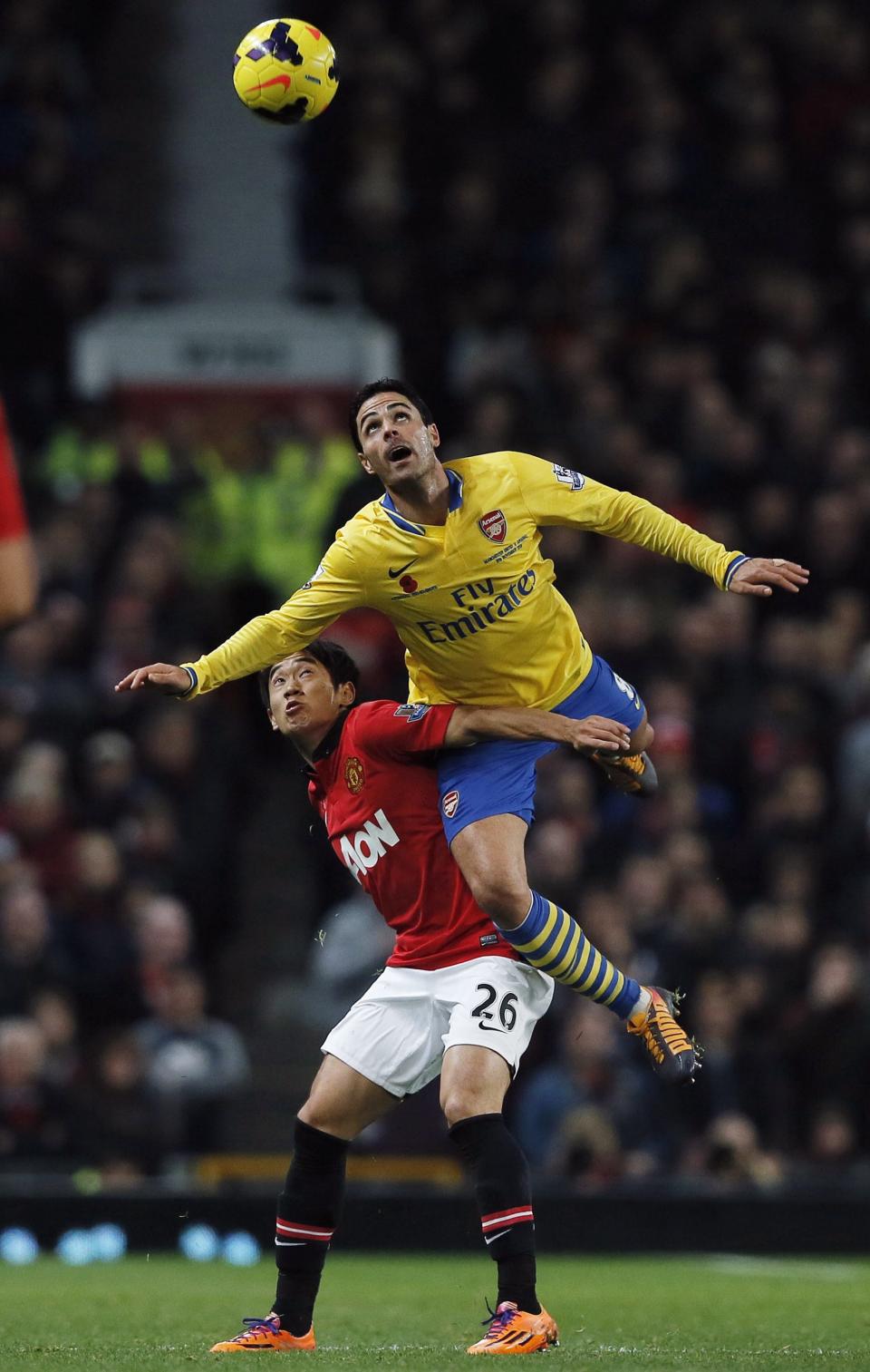 Manchester United's Shinji Kagawa (L) challenges Arsenal's Mikel Arteta during their English Premier League soccer match at Old Trafford in Manchester, northern England, November 10, 2013.