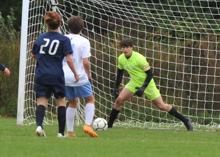Rockland goalkeeper Kellen Porter, right, moves in to deflect the shot of East Bridgewater's Orson Lizie, center, during boys soccer at Rockland High School, Monday, Oct. 3, 2022.