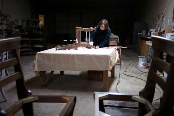 PHOTO: A factory worker uses sandpaper on a handmade wooden chair at the Colonial House Furniture Inc. wood shop in Auburn, Kentucky, Dec. 1, 2021. (Luke Sharrett/Bloomberg via Getty Images, FILE)