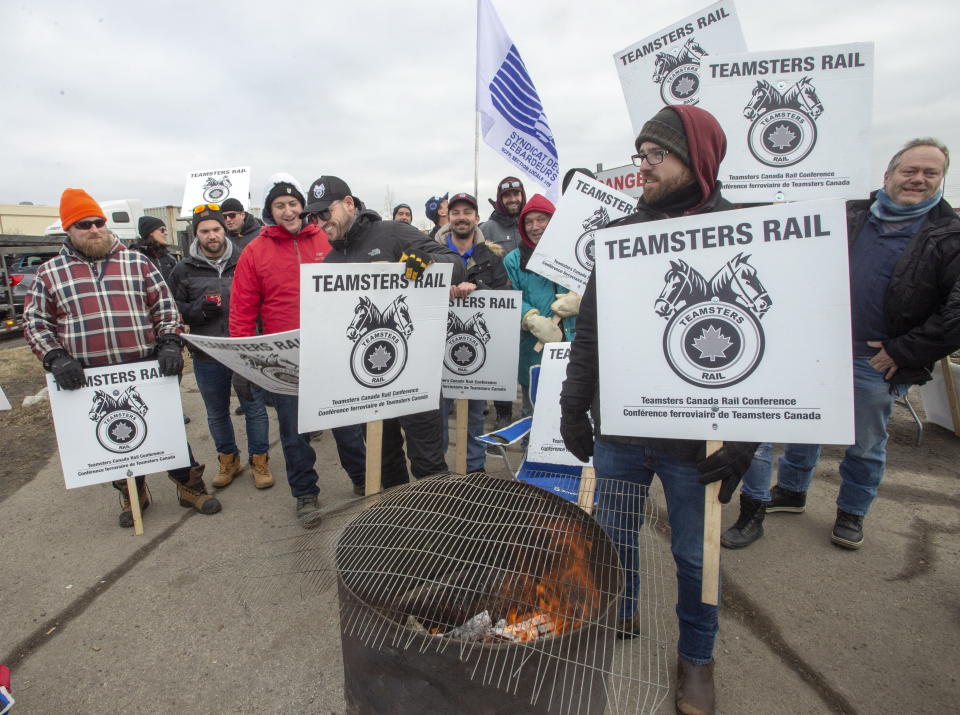 Striking Canadian National Railway workers picket in front of the company's Taschereau railyard Monday, November 25, 2019 in Montreal. (Ryan Remiorz/The Canadian Press via AP)