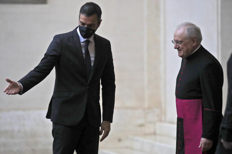 Spain's Prime minister Pedro Sanchez, left, is welcomed by Monsignor Leonardo Sapienza as he arrives at the San Damaso courtyard to meet Pope Francis, at the Vatican, Saturday, Oct. 24, 2020. (AP Photo/Alessandra Tarantino)