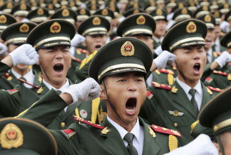 Paramilitary policemen and members of a gun salute team shout slogans at an oath-taking ceremony for the upcoming military parade to mark the 70th anniversary of the end of the World War Two, at a military base in Beijing, China, September 1, 2015. REUTERS/Stringer