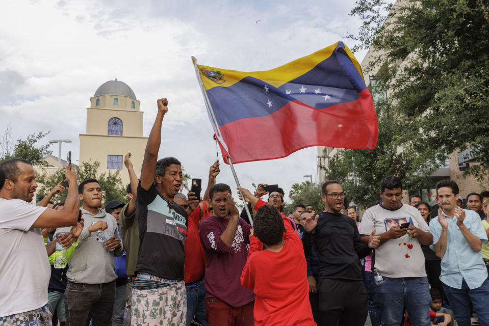 A young boy waves the Venezuelan flag at a vigil for the migrants that were killed and for several others that were injured Sunday, while waiting at a bus stop in Brownsville, Texas, Monday, May 8, 2023. (Michael Gonzalez