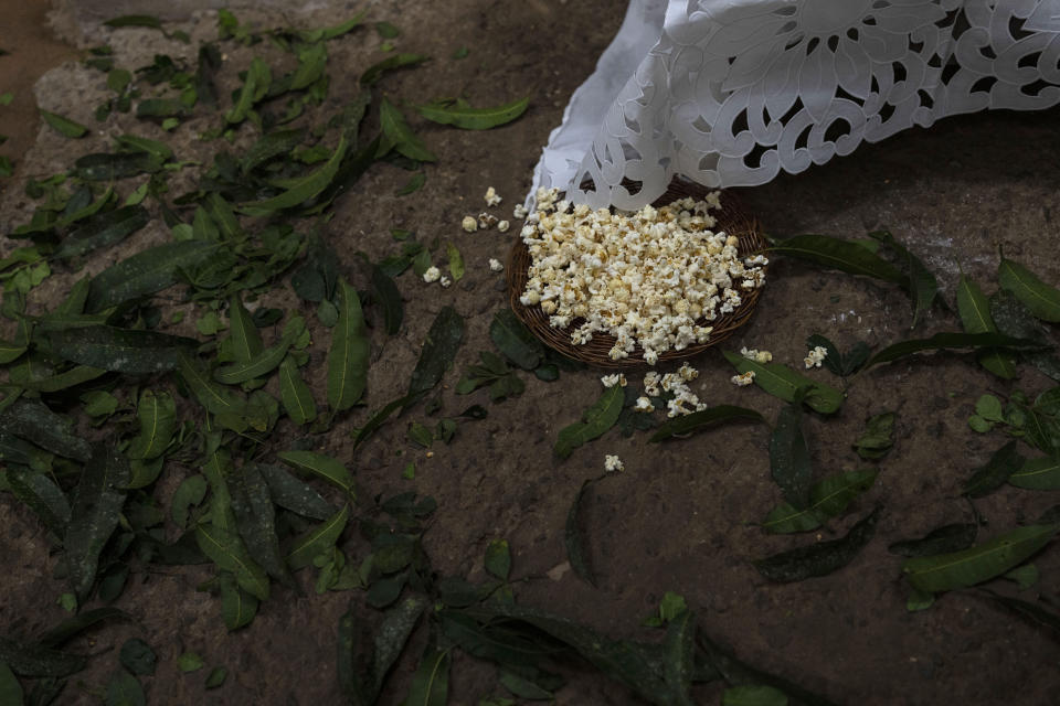 A bowl of popped Corn sits on the floor during a ritual honoring Obaluae, the deity of earth and health, at the Afro Brazilian faith Candomble temple, on the outskirts of Salvador, Brazil, Sunday, Sept. 18, 2022. (AP Photo/Rodrigo Abd)