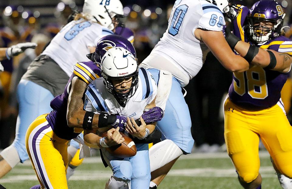 Ashland University's Michael Ayers (5) forces a fumble as he hits Northwood University quarterback Nate Gomez during college football action at Jack Miller Stadium Saturday, Oct. 1, 2022. TOM E. PUSKAR/ASHLAND TIMES-GAZETTE