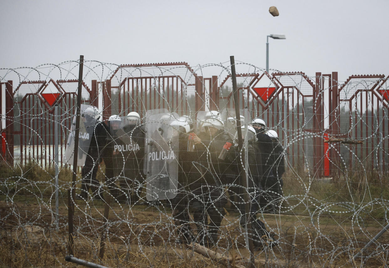 Polish serviceman use tear gas during clashes between migrants and Polish border guards at the Belarus-Poland border near Grodno, Belarus, on Tuesday, Nov. 16, 2021. Polish border forces say they were attacked with stones by migrants at the border with Belarus and responded with a water cannon. The Border Guard agency posted video on Twitter showing the water cannon being directed across the border at a group of migrants in a makeshift camp. (Leonid Shcheglov/BelTA via AP)