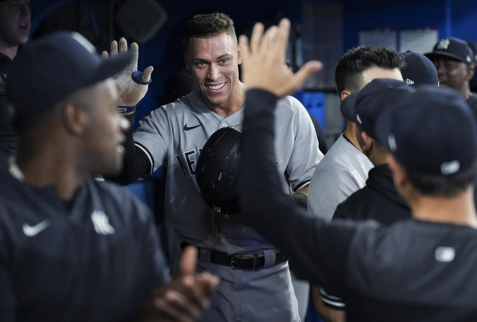 New York Yankees' Aaron Judge smiles in the dugout after hitting his 61st home run of the season, a two-run shot, against the Toronto Blue Jays during the seventh inning of a baseball game Wednesday, Sept. 28, 2022, in Toronto. (Nathan Denette/The Canadian Press via AP)
