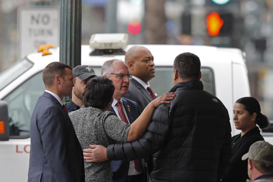 New Orleans Mayor Latoya Cantrell and Louisiana Gov. John Bel Edwards comfort the brother of one of the deceased construction workers near the Hard Rock Hotel, Thursday, Oct. 17, 2019, in New Orleans. The 18-story hotel project that was under construction collapsed last Saturday, killing three workers. Two bodies remain in the wreckage. (AP Photo/Gerald Herbert)