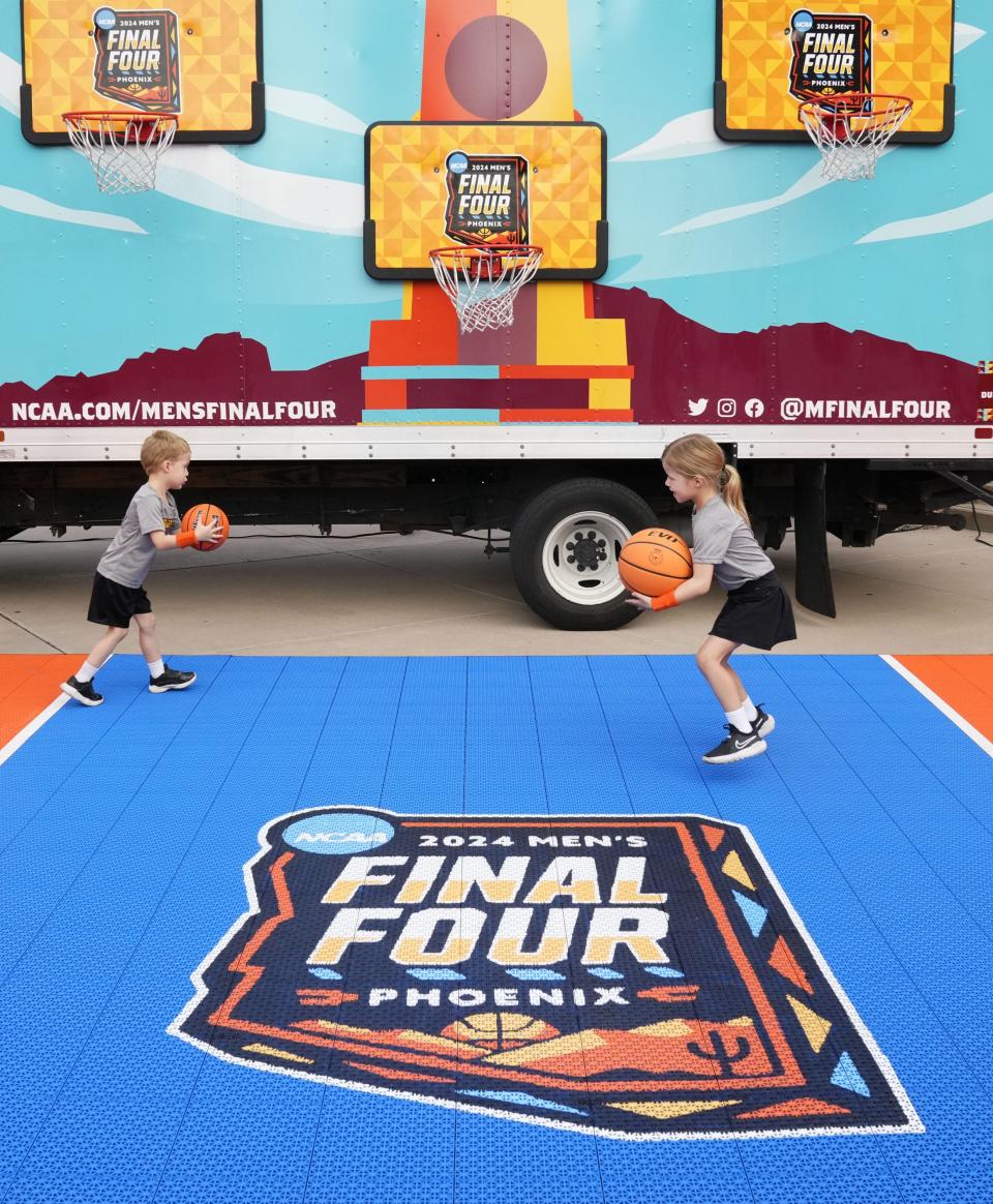 Kids play basketball at the kickoff of the 2024 NCAA Men's Final Four Fan Jam during a news conference at Desert Financial Arena.