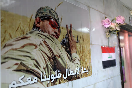 A poster of a Hashid Shaabi fighter is seen in a hospital run by the Shia militia group in Hilla, Iraq, July 5, 2018. The text on the poster reads, "Heroes, our hearts with you". Picture taken July 5, 2018. REUTERS/Marius Bosch