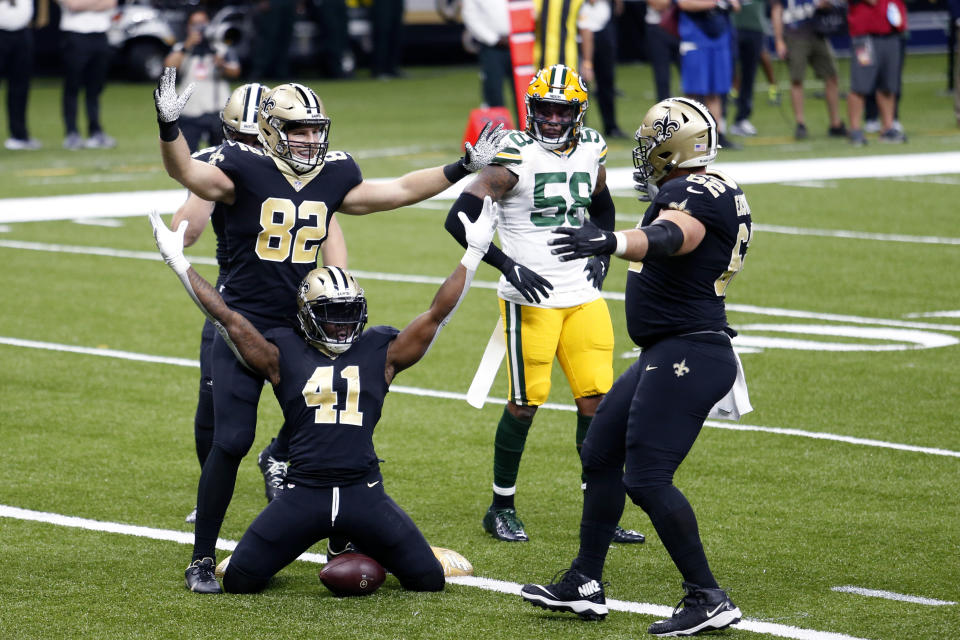 New Orleans Saints running back Alvin Kamara (41) celebrates his touchdown carry with tight end Adam Trautman (82) and offensive guard Nick Easton (62) as Green Bay Packers inside linebacker Christian Kirksey (58) watches, in the first half of an NFL football game in New Orleans, Sunday, Sept. 27, 2020. (AP Photo/Brett Duke)