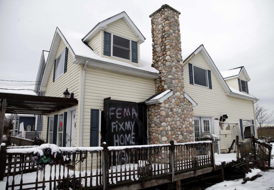 A sign is displayed on a house damaged by Superstorm Sandy in the Oakwood Beach section of Staten Island, New York, Thursday, Nov. 8, 2012. (AP Photo/Seth Wenig)