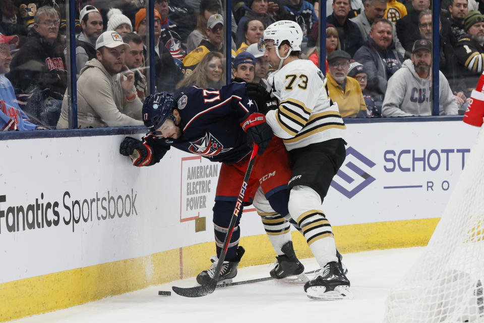 Columbus Blue Jackets' Justin Danforth, left, and Boston Bruins' Charlie McAvoy fight for the puck during the second period of an NHL hockey game, Monday, Nov. 27, 2023, in Columbus, Ohio. (AP Photo/Jay LaPrete)