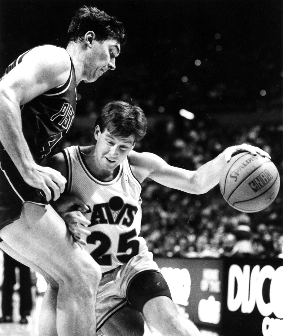 The Cleveland Cavaliers' Mark Price, right, drives to the basket against the Detroit Piston' Bill Laimbeer at the Richfield Coliseum, Dec. 15, 1988, in Richfield, Ohio.
