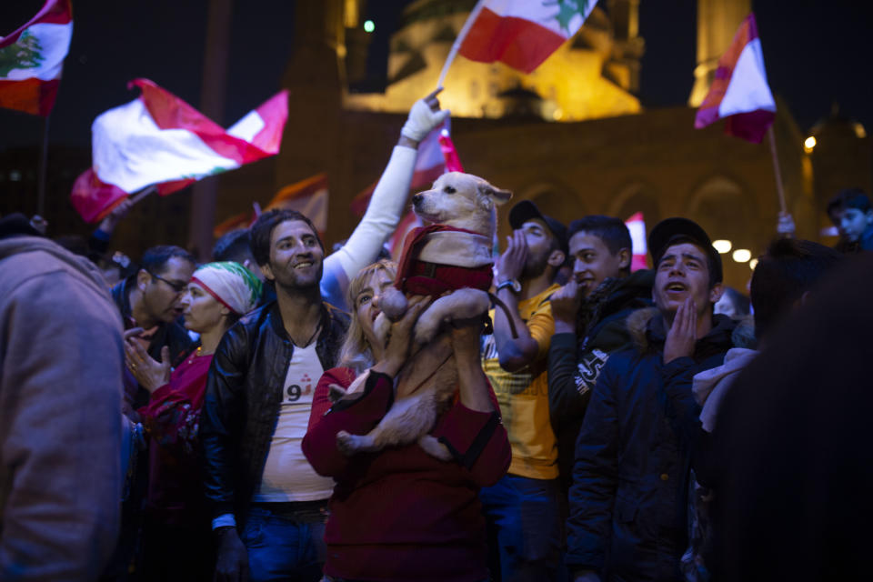 An anti-government protester holds up her dog at a rally in Martyrs' Square in Beirut, Lebanon, Sunday, Dec. 22, 2019. (AP Photo/Maya Alleruzzo)