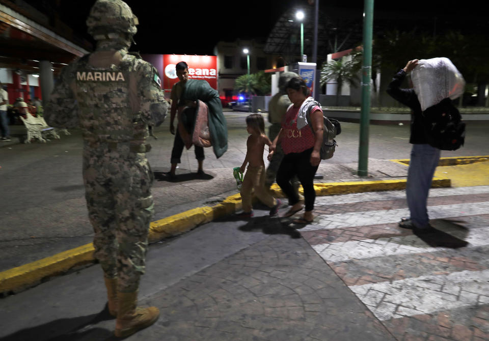 A Mexican marine stands by as camping migrant families are evicted from a park in Tapachula, Mexico, early Wednesday, May 29, 2019. Authorities cleared the park of camping Central American migrants and the makeshift encampment of Haitians and African migrants outside the immigration detention center near the Guatemala border. (AP Photo/Marco Ugarte)