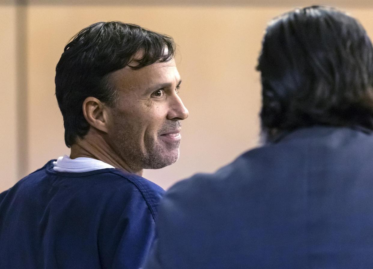 Scott Strolla, pictured here in 2019, smiles at his defense attorney, his brother Cory Strolla, during a court appearance. The foot doctor pleaded guilty to two counts of sexual battery on Aug. 8, 2023.
