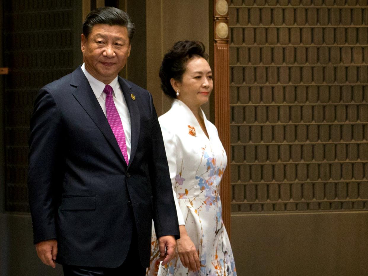 Chinese President Xi Jinping and his wife Peng Liyuan arrive at a summit with Russia, India, Brazil and South Africa in southeast China, with domestic and international issues on his mind Mark Schiefelbein/AP: Mark Schiefelbein/AP