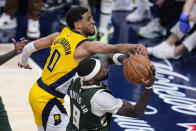 Milwaukee Bucks forward Bobby Portis (9) grabs a rebound behind Indiana Pacers guard Tyrese Haliburton (0) during the second half in Game 2 in an NBA basketball first-round playoff series, Friday, April 26, 2024, in Indianapolis. (AP Photo/Michael Conroy)