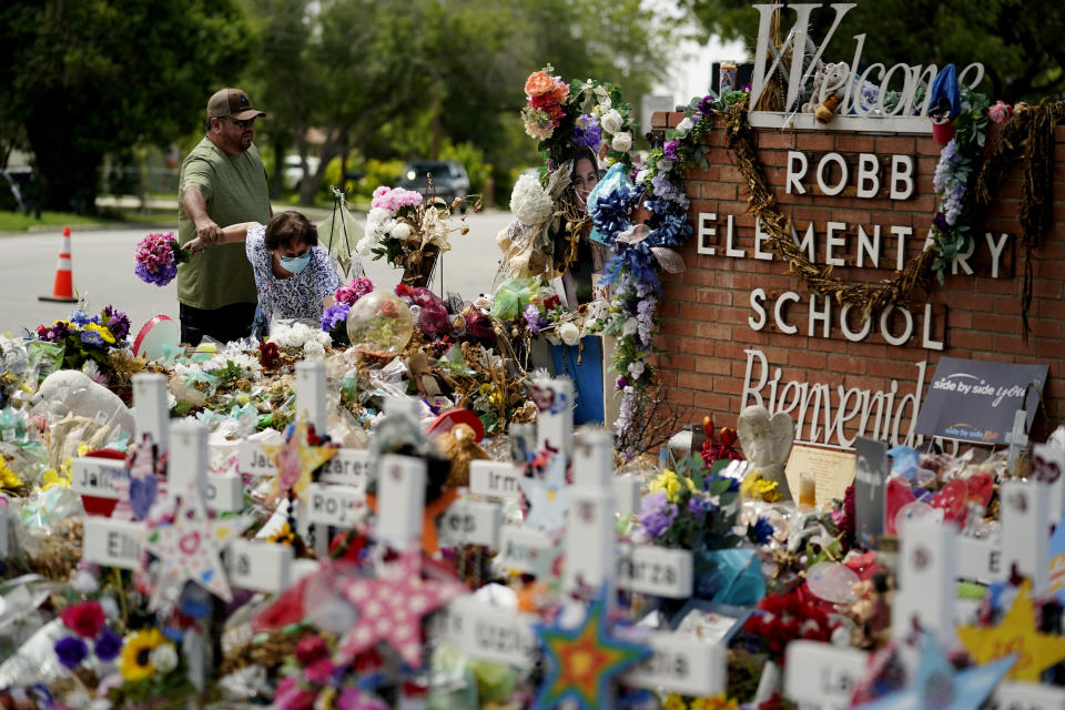 Retired teachers Raul Noyola and Ofelia Noyola visit a memorial honoring the school shooting victims at Robb Elementary, Tuesday, July 12, 2022, in Uvalde, Texas. (AP Photo/Eric Gay)