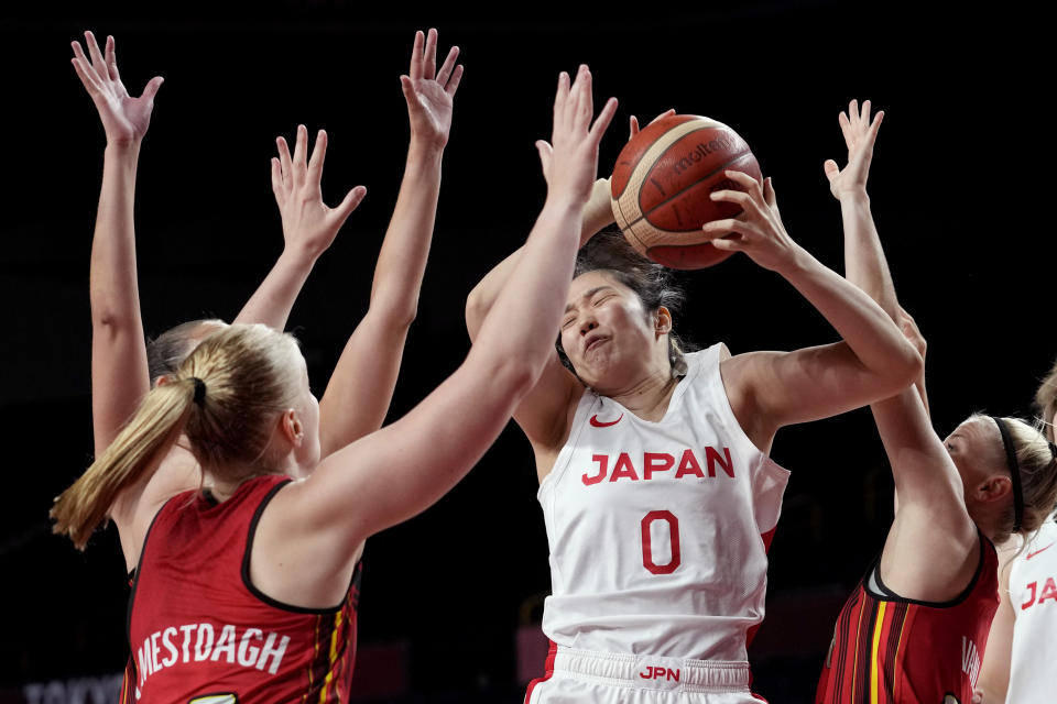 Japan's Evelyn Mawuli (30) grabs a rebound over Belgium's Hanne Mestdagh, left, and Belgium's Julie Vanloo , right, during a women's basketball quarterfinal game at the 2020 Summer Olympics, Wednesday, Aug. 4, 2021, in Saitama, Japan. (AP Photo/Eric Gay)