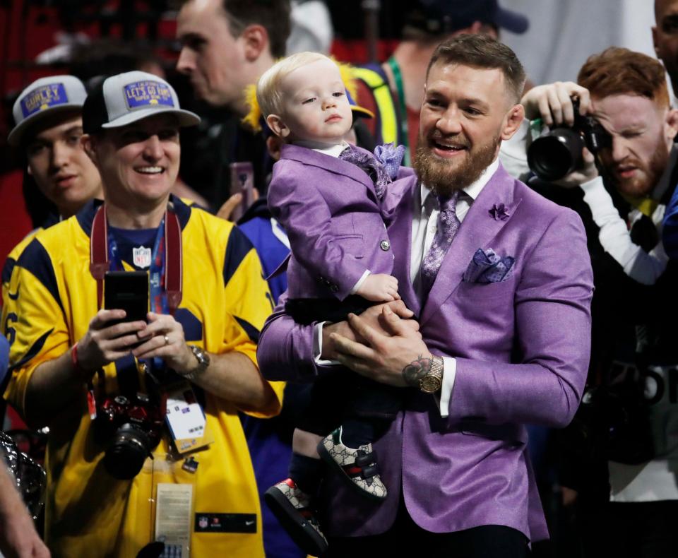 Proud dad: Conor McGregor and his son wear matching purple suits (Reuters)