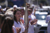 Ana Maria Branza of Romania participates in the Olympic torch relay in Marseille, southern France, Thursday, May 9, 2024. Torchbearers are to carry the Olympic flame through the streets of France' s southern port city of Marseille, one day after it arrived on a majestic three-mast ship for the welcoming ceremony. (AP Photo/Daniel Cole)