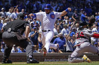 Chicago Cubs' Willson Contreras, center, scores on a two-run single by Jonathan Villar as Atlanta Braves catcher William Contreras waits for the ball during the first inning of a baseball game in Chicago, Saturday, June 18, 2022. (AP Photo/Nam Y. Huh)