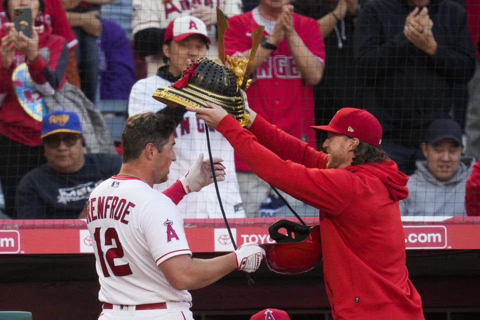 Los Angeles Angels' Brett Phillips, right, places a kabuto on the head of Hunter Renfroe (12) after Renfroe hit a home run during the second inning of a baseball game against the Houston Astros in Anaheim, Calif., Monday, May 8, 2023. (AP Photo/Ashley Landis)