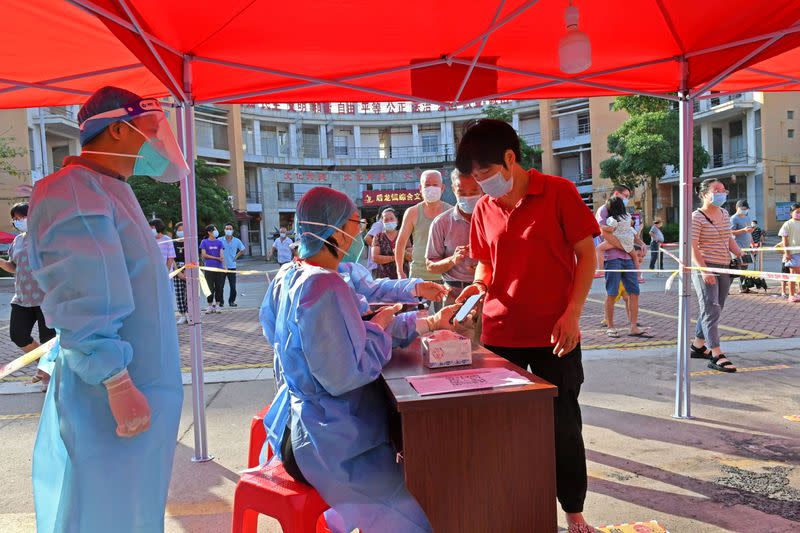 FILE PHOTO: Residents register to take nucleic acid tests at a testing site in Quanzhou, Fujian