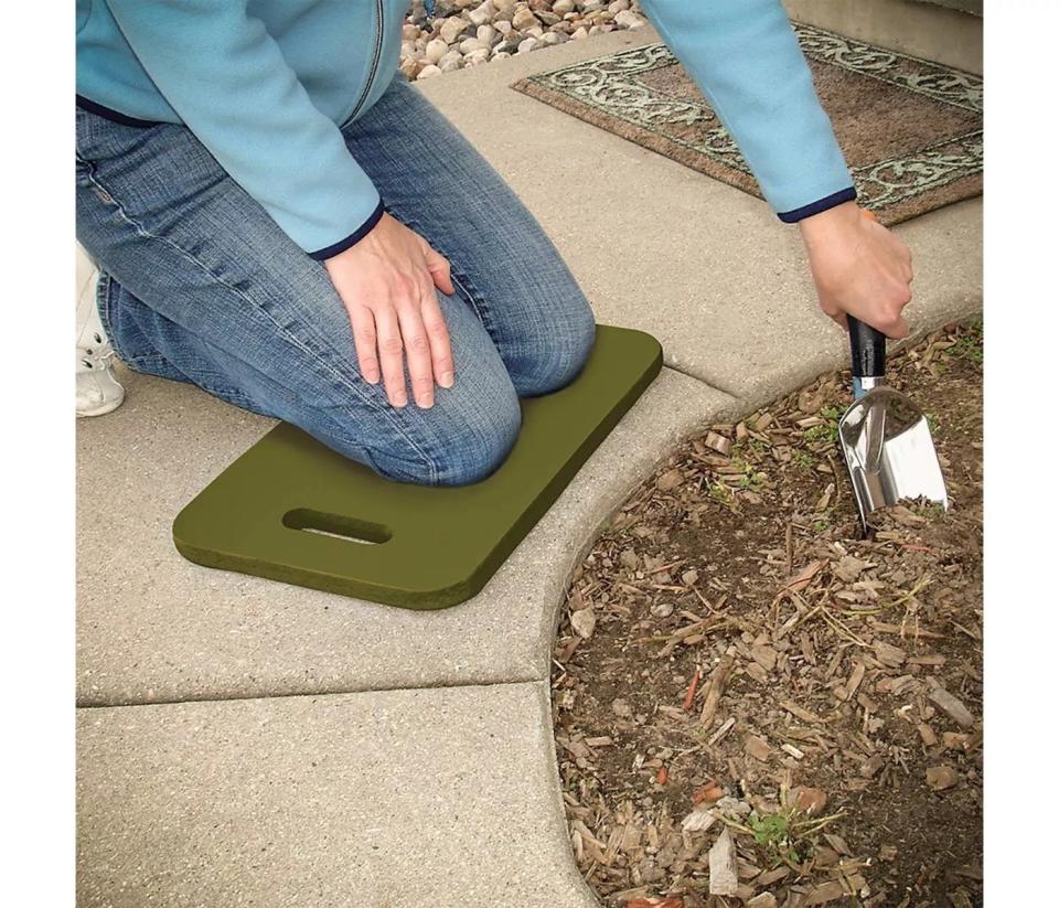A model using the kneeling pad and trowel in a garden
