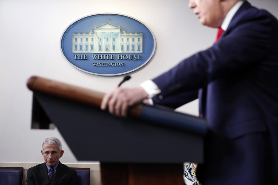 FILE - In this April 9, 2020, file photo, Dr. Anthony Fauci, director of the National Institute of Allergy and Infectious Diseases, listens as President Donald Trump speaks about the coronavirus in the James Brady Press Briefing Room of the White House in Washington. (AP Photo/Andrew Harnik, File)