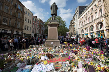 Messages and floral tributes left for the victims of the attack on Manchester Arena lie around the statue in St Ann's Square in central Manchester, May 24, 2017. REUTERS/Jon Super