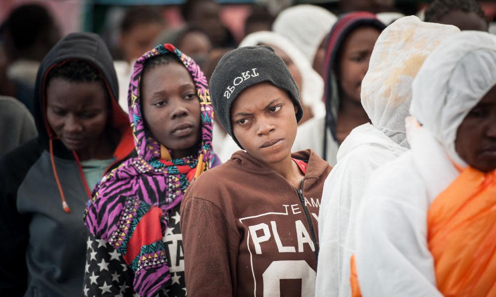 Migrants queue up after arriving by boat in Salerno, Italy.