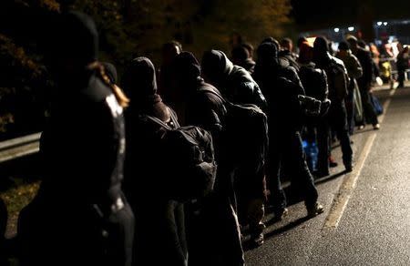 Migrants stay in a queue after crossing the Austrian-German border from Achleiten, Austria, in Passau, Germany, October 29, 2015. REUTERS/Michaela Rehle