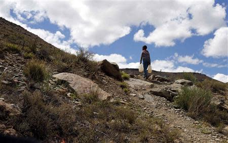 A child carries water in Nieu-Bethesda in the Karoo October 27, 2013. REUTERS/Mike Hutchings