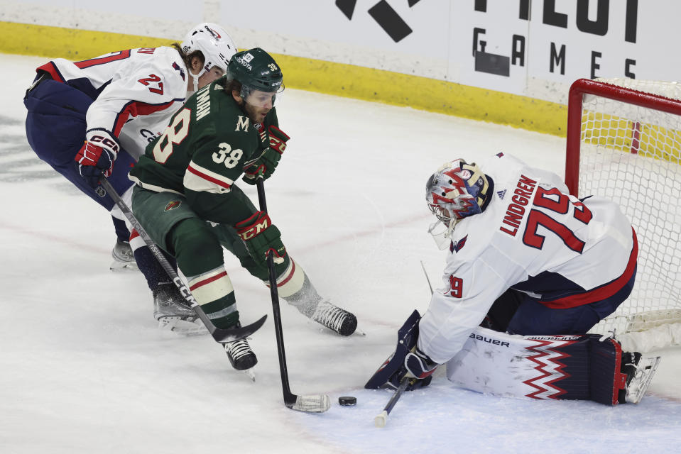 Minnesota Wild right wing Ryan Hartman (38) tries to get the puck into the net against Washington Capitals goaltender Charlie Lindgren (79) during the first period of an NHL hockey game Sunday, March 19, 2023, in St. Paul, Minn. (AP Photo/Stacy Bengs)