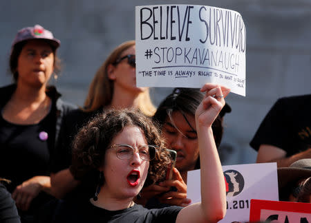 A demonstrator holds a placard outside Los Angeles City Hall to protest the Senate Judiciary committee's vote on President Trump's U.S. Supreme Court pick Brett Kavanaugh, in Los Angeles, California, U.S., September 28, 2018. REUTERS/Mike Blake