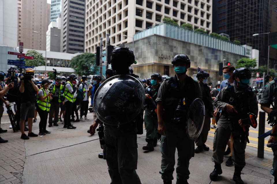 Riot police stand guard during a protest outside the Central Government Complex as a second reading of a controversial national anthem law takes place in Central district, Hong Kong, Wednesday, May 27, 2020. Hong Kong police massed outside the legislature complex Wednesday, ahead of debate on a bill that would criminalize abuse of the Chinese national anthem in the semi-autonomous city. (AP Photo/Kin Cheung)