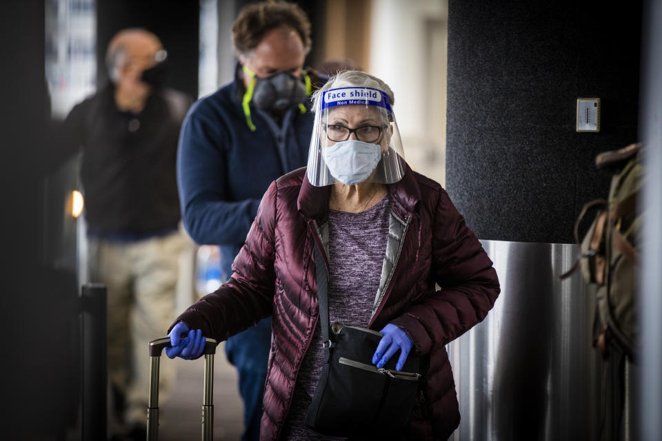 LOS ANGELES, CA - NOVEMBER 23: Travelers wearing masks get their tickets and check luggage at LAX as the Thanksgiving holiday getaway period gets underway on Monday, Nov. 23, 2020 in Los Angeles, CA. Millions of Americans are carrying on with their travel plans ahead of Thanksgiving weekend despite the CDC's urgent warnings to stay home as the number of daily cases and hospitalizations in the country continue to hit record highs. Confirmed cases in the U.S. for the disease topped 12 million on Saturday as more than 193,000 new infections were recorded in the US on Friday. This broke the previous record for the largest single-day spike on Thursday - and over 82,000 patients are now hospitalized across the country. (Allen J. Schaben / Los Angeles Times via Getty Images)