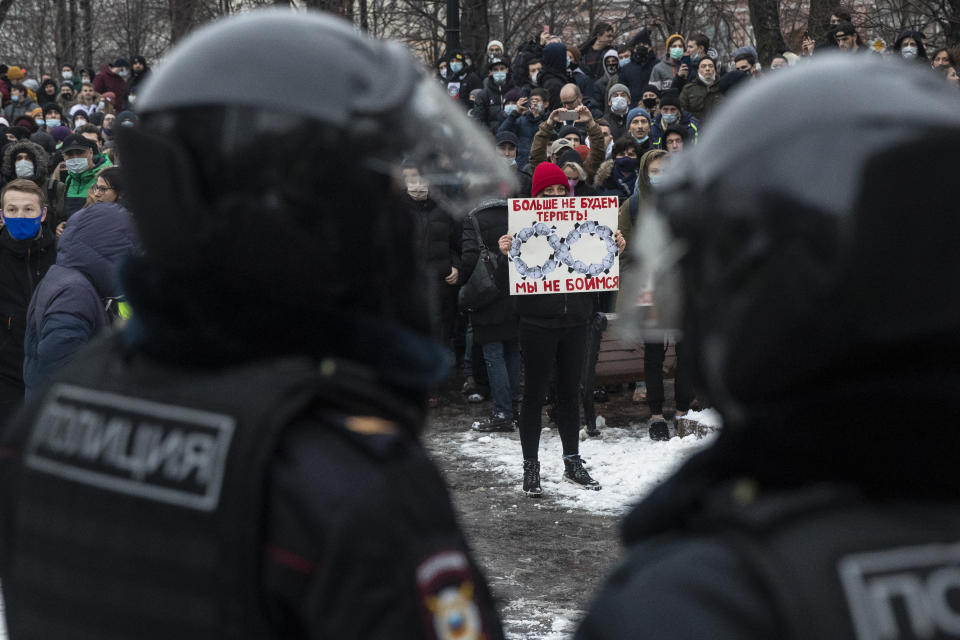 A woman holds a banner with portraits of Russian President Vladimir Putin and reads "We're not gonna take it anymore! We are not afraid", during a protest against the jailing of opposition leader Alexei Navalny in Moscow, Russia, Saturday, Jan. 23, 2021. Russian police on Saturday arrested hundreds of protesters who took to the streets in temperatures as low as minus-50 C (minus-58 F) to demand the release of Alexei Navalny, the country's top opposition figure. (AP Photo/Pavel Golovkin)